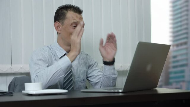 A businessman who is a company employee using a laptop to work in an office Has been frustrated and failed in his work and felt very sad.
