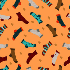 Multi-colored socks on a yellow-brown background with a seamless pattern. Vector image. Many different socks scattered on a bright background.