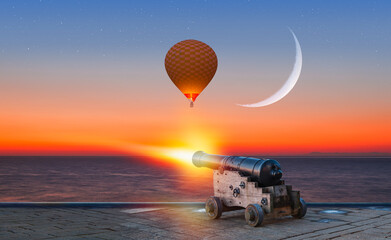 Ramadan Concept - Ramadan kareem cannon with crescent moon at amazing sunset