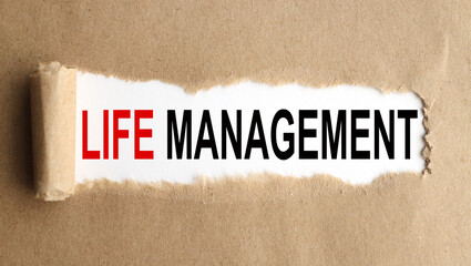 LIFE MANAGEMENT. text on white paper on torn paper background