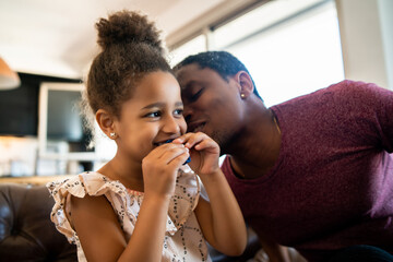 Daughter and father playing together at home.