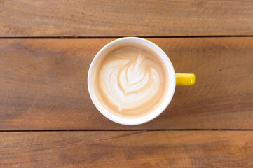 A cup of latte art on wood table
