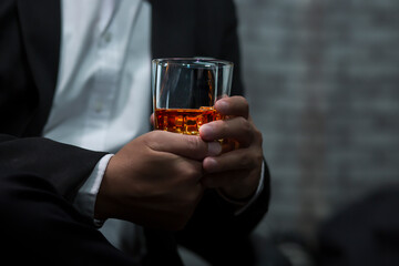 Closeup businessmen holding a glass of whiskey