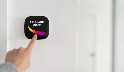 Air quality index showing on smart home domotic tech device. Woman touching touchscreen for clean...