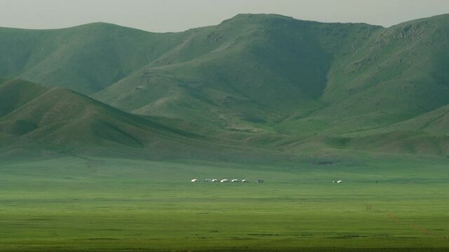 Plain in treeless wide valley.Grassland prairie meadow&nbsp;wold pasture steppe plateau tableland lowland mountain mountainous terrain geography slope ridge hill vast&nbsp;landscape large long nature Mongolia.