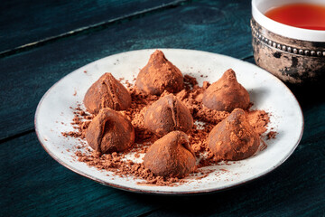 Chocolate truffles and tea on a dark blue wooden table