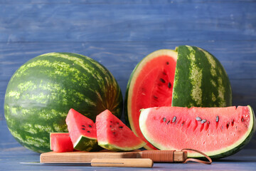 Wooden board with slices of ripe watermelon on table