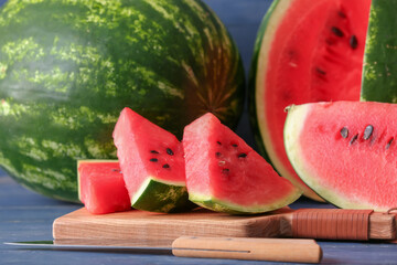 Wooden board with slices of ripe watermelon on table