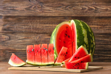 Board with slices of ripe watermelon on wooden table