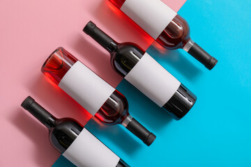 Bottles of wine with blank labels on color background