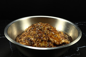 Marinated raw pork meat with pepper and mixed local herbal in the stainless bowl. Preparation food concept. 