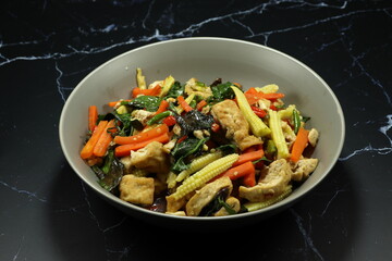 Fried and stirred mixed vegetable, chilly and tofu serving on the plate. Famous vegetarian menu in Asia restaurant. 