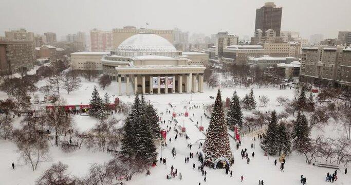  people go ice skating near the opera house and New Year trees