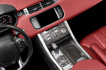 Fototapeta na wymiar Red luxury modern car Interior. Steering wheel, shift lever and dashboard. Detail of modern car interior. Automatic gear stick. Part of leather seats with stitching in expensive car