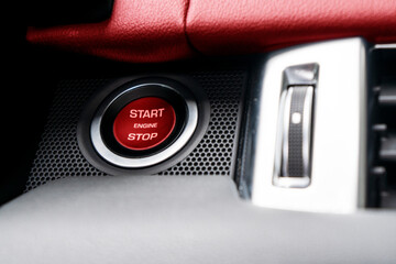 Car dashboard with focus on red engine start stop button. Modern car interior details. start/stop...