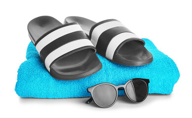 Male flip-flops with towel and sunglasses on white background
