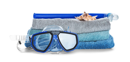 Stack of clean towels, snorkeling mask and tube on white background