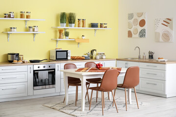 Interior of modern kitchen with dining table and chairs
