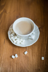 A cup of marshmallow coffee on a brown wooden table