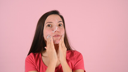 Portrait of woman cleaning her face with a foam treatment. Problem skin care concept.
