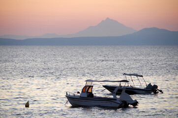 two fishing boats at dawn against the backdrop of the holy Mount Athos