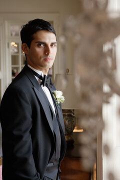 Hispanic man wearing tuxedo with boutonniere