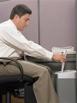 Side view of businessman shredding papers