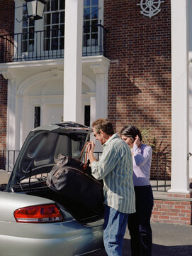 Couple loading trunk of car