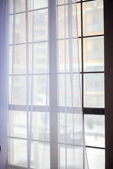 Large panoramic windows covered with white tulle