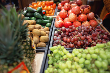 Various fruits and berries are sold at the tropical fruit shop. Counter with grapes, pineapples and pomegranates