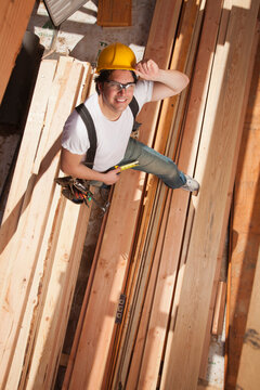 Mixed race construction worker standing on lumber