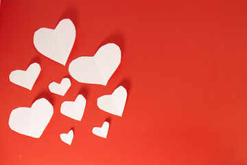 white paper hearts on red isolated background. valentine's day cards with copy space