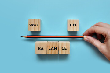 Wooden cubes in the form of scales and the inscription: life and work. Balance between life and...