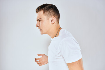 Man in white t-shirt displeased facial expression gesturing with hands studio lifestyle