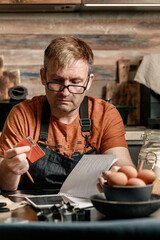 Man with credit card shopping online in a grocery store. Life style photography. Home kitchen. Food Delivery Service. Vertical shot