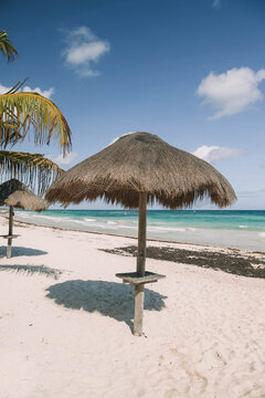 Brown nipa hut on white sand beach