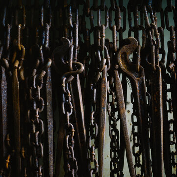 Close up of rusty chains hanging against side of ship