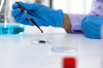 Scientist holding Coronavirus covid-19 infected blood sample tube DNA testing of the blood in the laboratory with blood sample collection tubes and syringe Coronavirus Covid-19 vaccine research.