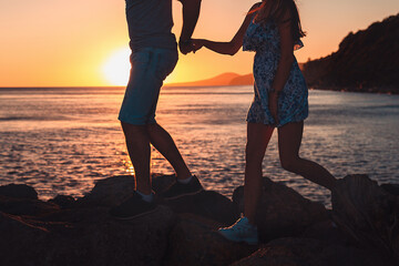 Summer holiday. Silhouette of a young couple running along the beach. Close up. Side view