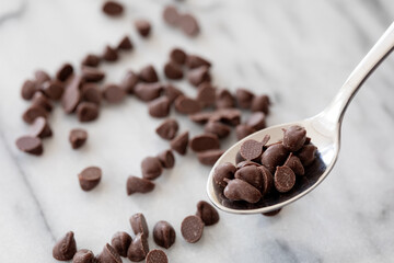 大理石の上でスプーンに乗ったチョコレートチップ