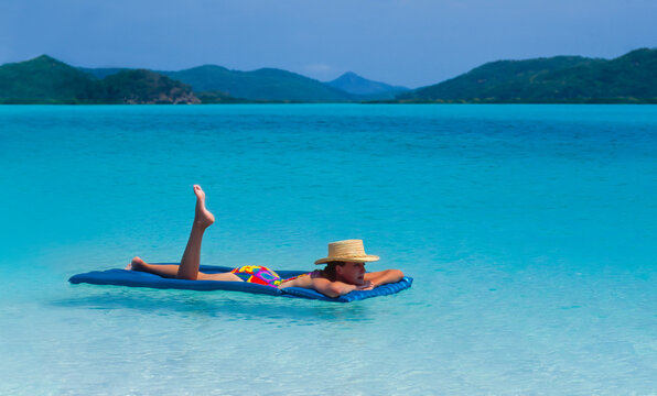 Young Woman floating on a lilo at Whitehaven Beach - Queensland