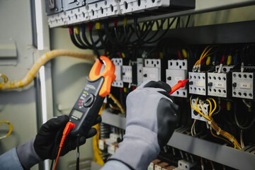 Electrical engineers test electrical installations and wiring on protective relays, measuring them...