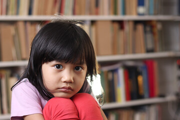 Beautiful cute little Asian baby girl in library, child portrait