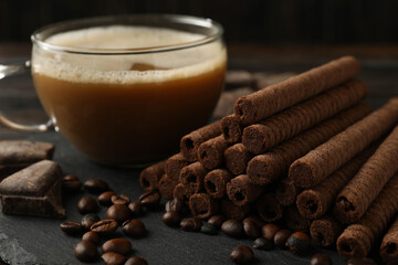 Concept of breakfast with coffee and chocolate wafer rolls, close up