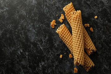 Wafer rolls with condensed milk on black smokey background