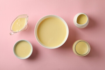Obraz na płótnie Canvas Bowls with condensed milk on pink background
