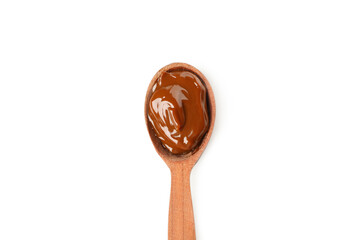 Spoon with caramel condensed milk isolated on white background