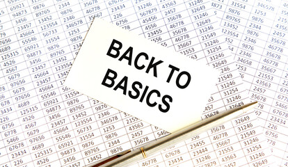 Obraz premium On the business card the text Back to Basics, next to the pen, the background are reports.