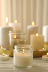 Burning scented candles for relax on white wooden table