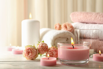 Pink scented candles on white wooden background